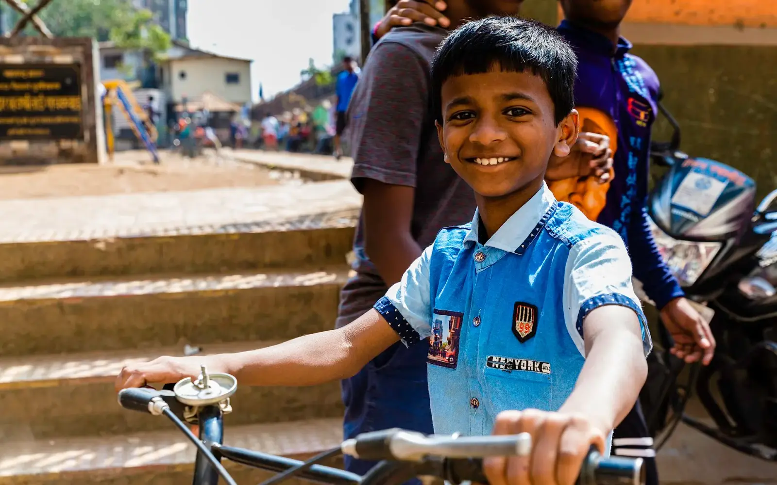 A smiling schoolboy on a bicycle